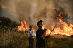 Locals shout as they try to extinguish a wildfire in Caramulo, centra